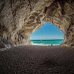 brown tunnel near body of water
